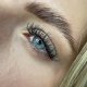 Modelo rubia con ojos azules y pestañas largas.